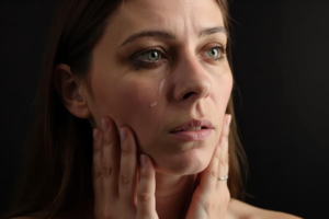 Primer plano de un rostro femenino con lágrimas, reflejando la lucha emocional. La imagen representa cómo afecta la autoexigencia al cuerpo, mostrando el impacto del estrés y la presión personal a través de la intensidad de una expresión de vulnerabilidad.