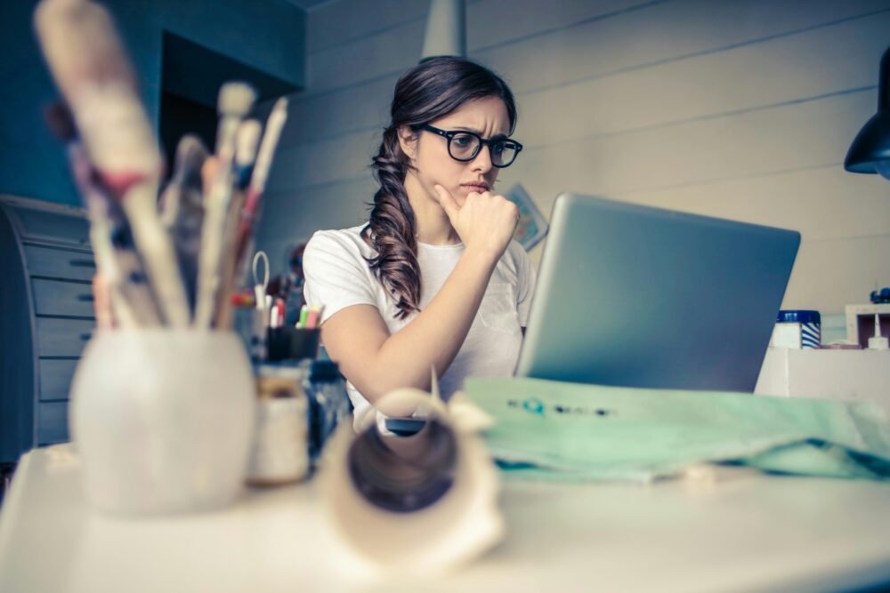Mujer intentando concentrarse en algo que ve en su laptop