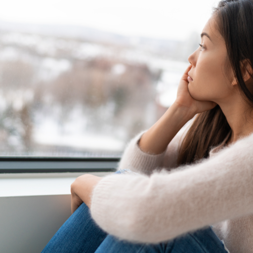 Una mujer mirando por la ventana refleja la incertidumbre emocional en las relaciones. Explora cómo manejar estos sentimientos y fortalecer tus vínculos, en Micentrolasrozas.es. 🌿💔